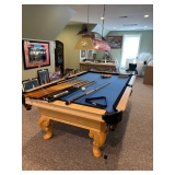A nice Olhausen pool table with a variety of cues and accessories. 