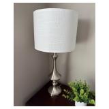 brushed steel finish table lamp with a white fabric drum shade