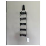 wall-mounted metal wine rack, featuring five slots for bottles 