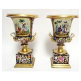 1022	PAIR OF HAND PAINTED DOUBLE HANDLED PORCELAIN URNS, EACH WITH FLOWERS, GILT TRIM ACCENTS AND AS