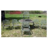 1188	ORNATE CAST METAL ROUND PATIO TABLE WITH 6 ARM CHAIRS, TABLE APPROXIMATELY 56 IN R X 30  IN H