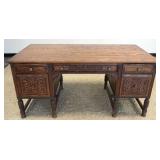 1162	ORNATE OAK DESK WITH 3 DRAWERS, 2 DOORS. HAVING CARVING ON DRAWER FRONTS AND BACK OF DESK, 2 PU