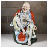 Chinese Porcelain Elder Figure | A laughing Luohan (or Buddhist immortal) seated and holding a cup o
