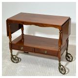 Antique Wood Bar Cart | Of nicely figured wood with a gloss finish, having two lower drawers with br