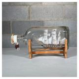 Ship in a Bottle | On a wood display stand with metal plaque reading Boemor 1818 Dimensions: l. 9 in