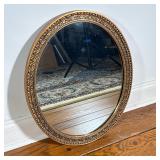 OVAL GILT MIRROR WITH FLORAL VINE AND BEADED MOULDING