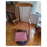 Wood rocking chair, foot rest with red fabric, braided rug