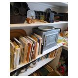 cookbooks, bread box, pots with lids, cast iron pans and muffins