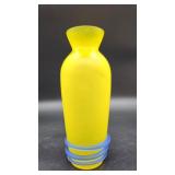 A cased yellow satin glass bud vase with blue applied coil base and flared rim, measuring 7.5 inches