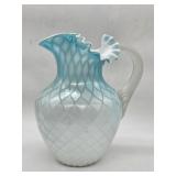 A pale blue and white diamond quilted art glass pitcher with applied clear handle and ruffled rim, d