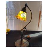 A very heavy painted glass table lamp with a floral design shade and ornate metal base, in working c