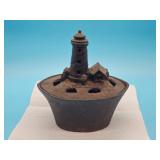 Cast iron lighthouse-shaped incense burner with removable lid; measures 9" T