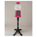 Red and black floor-standing gumball vending machine with clear globe and decorative cast metal base