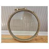 Early 20th-century industrial maritime brass porthole window with a circular clear-glass pane, remov