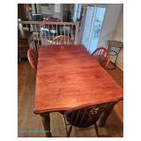 Wood dining table with turned legs and four matching spindle-back side chairs with carved splats; me