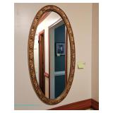  Oval wall mirror with gold-tone floral and foliate frame; measures 19" x 37"