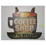A large painted wood wall sign in the shape of a coffee cup reading "Coffee Shop Open 
