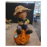 Scarecrow sitting on a Pumpkin lights up