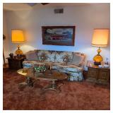Mid century furniture, including a vintage sofa, coffee table, end tables, lamps, and art