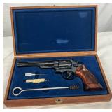 Features include a 6.5-inch barrel, blued finish, and checkered wooden grips