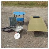 Solar panel with camping gear including BBQ grill, cot, and table