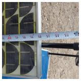 Solar panel with camping gear including BBQ grill, cot, and table