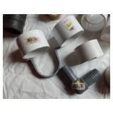 Assorted Plumbing Supplies and Tools including Drill Powered Drain Auger, Toilet Seat, and Various Fittings