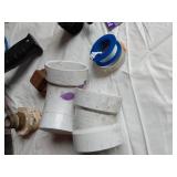 Assorted Plumbing Supplies and Tools including Drill Powered Drain Auger, Toilet Seat, and Various Fittings
