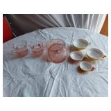 Vintage kitchenware set including Menschik-Goldman measuring cups, pink Depression glass bowls, and floral glass mugs