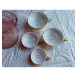 Vintage kitchenware set including Menschik-Goldman measuring cups, pink Depression glass bowls, and floral glass mugs