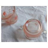 Vintage kitchenware set including Menschik-Goldman measuring cups, pink Depression glass bowls, and floral glass mugs