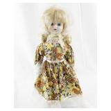 Vintage Porcelain Doll with Blonde Hair and Floral Dress