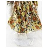 Vintage Porcelain Doll with Blonde Hair and Floral Dress