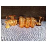 Gold colored glass pitcher, 6 mugs, small drinking glass and 1 brown pitcher