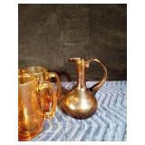 Gold colored glass pitcher, 6 mugs, small drinking glass and 1 brown pitcher