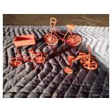 Miniature red metal bicycles, tricycle and wagon