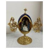 Collection of Holiday Figurines and Decor Including Angel, Nativity Egg, Bells, and Winter Children