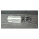 Assorted Electronics and Accessories Including Brookstone Alarm Clock, Power Supplies, Cables, and Power Strip