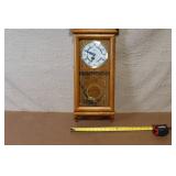 Wall Mount Pendulum Clock with Oak Finish and Roman Numeral Dial