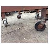 Heavy-duty industrial rolling cart probably designed for transporting pipes or beams 62 ¾” l x 48” w x 33”