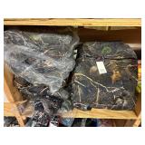 3 shelves of camo/orange hunting gear. Jackets, sweatshirts, hats, foam footballs