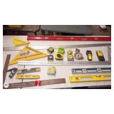 Assorted Measuring and Layout Tools including Tape Measures, Levels, and Squares