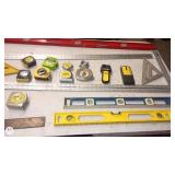 Assorted Measuring and Layout Tools including Tape Measures, Levels, and Squares