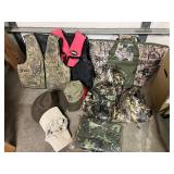 Assorted Hunting Gear Collection with Vests, Caps, Camo Jacket, and Carry Bags