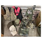 Assorted Hunting Gear Collection with Vests, Caps, Camo Jacket, and Carry Bags