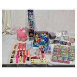 Lot of Vintage Toys and Collectibles including Little Tikes Piggy Bank, Toy Story Kite, and Trading Cards Like PukeMon