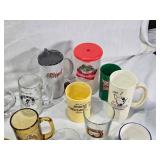 Assorted mugs and glasses including Kimball MN glass mug, Lutsen Glass, Oakley National Bank, Budweiser mugs, and various commemorative mugs