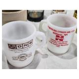 Assorted mugs and glasses including Kimball MN glass mug, Lutsen Glass, Oakley National Bank, Budweiser mugs, and various commemorative mugs