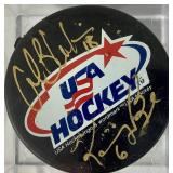 USA Hockey Black Pucks Autographed by Alana Blahok #18 and Karen Bye #6