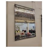 A Silver Framed Beveled Mirror with Rivet Accents.